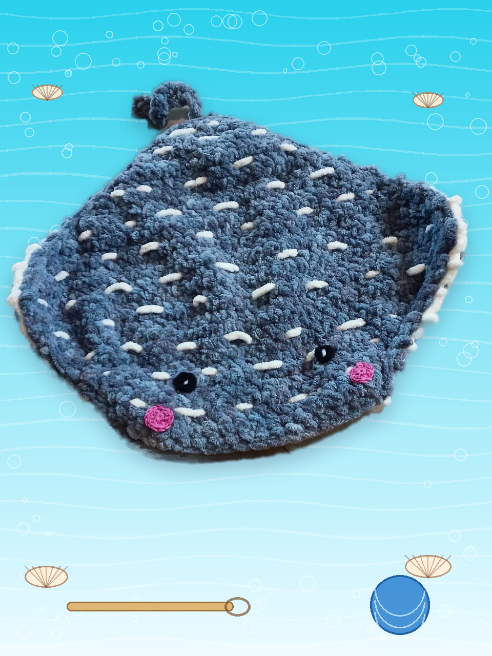 Nath's real handmade crocheted royal blue velvet stingray on a vibrant ocean craft background with white embroidered dots, white crocheted eyes, and pink crocheted cheeks